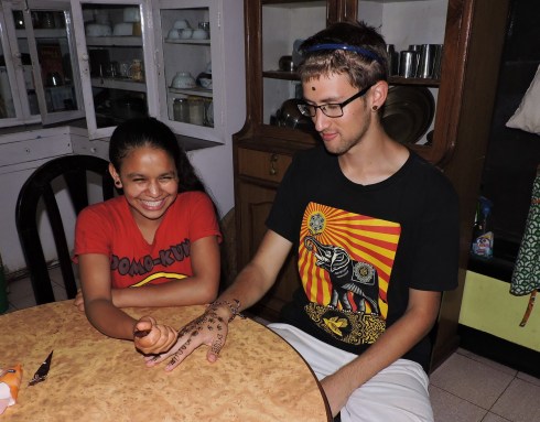 Januka applying Henna designs to one of the guests hands (face, ears)
