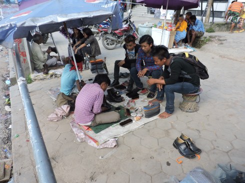 Working at the roadside: cleaning shoes