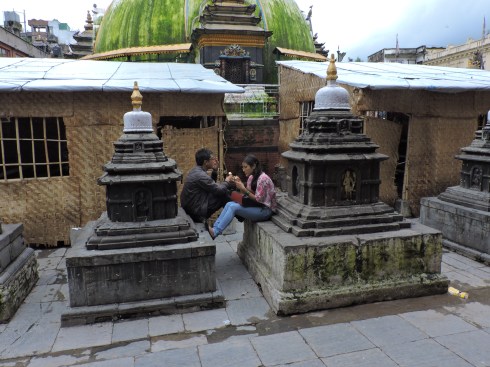 Mini stupa dating with icecream; background: two makeshift schoolrooms and the the big stupa 